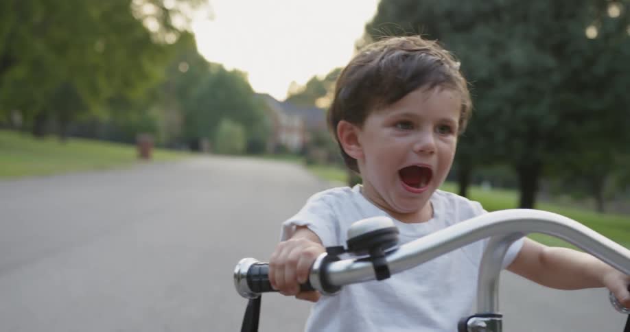 Young child rides a tricycle on the road