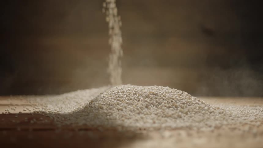 Rice grains being being dropped into a pile