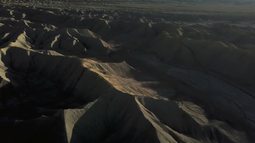 Shadows over a hilly desert landscape