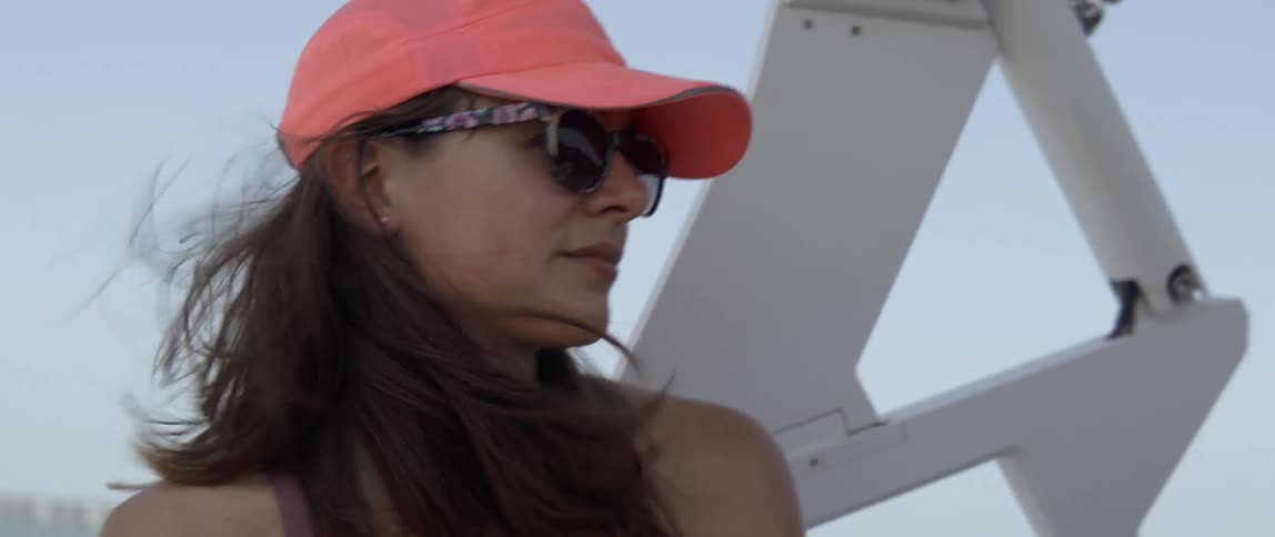 A woman's hair is blown by the breeze on the back of a boat