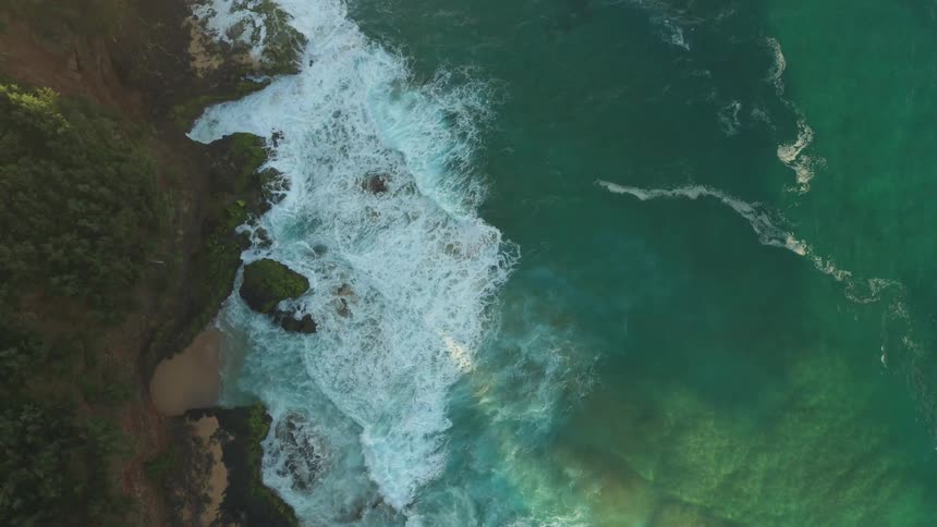 Water splashes up to a rocky shore