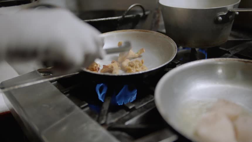 Person cooks multiple dishes on a hot stove top