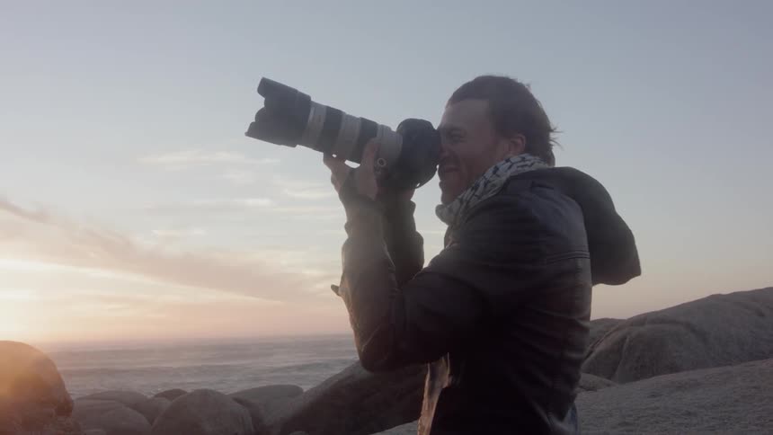 A man is taking photographs on a very windy day