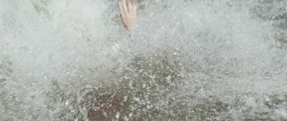 A man falls and splashes into the water