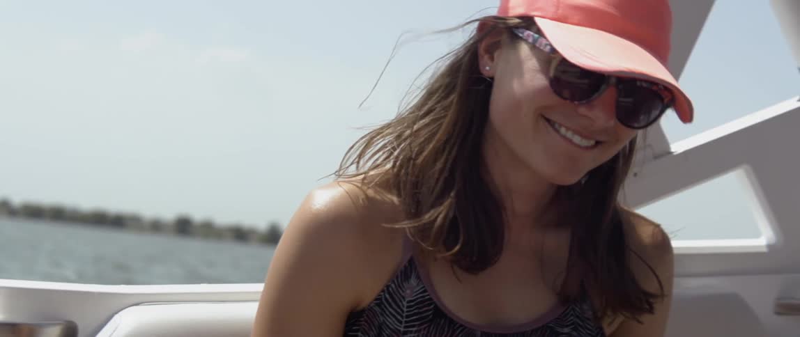 Smiling woman rides on a boat on a sunny day