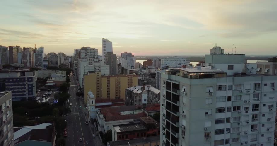 Sun sets over a large city near a body of water