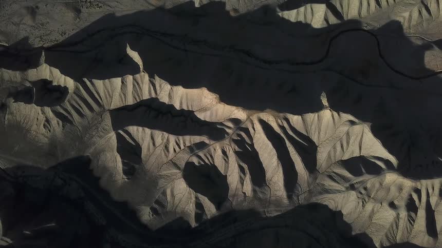 Shadows fall over hilly desert landscape