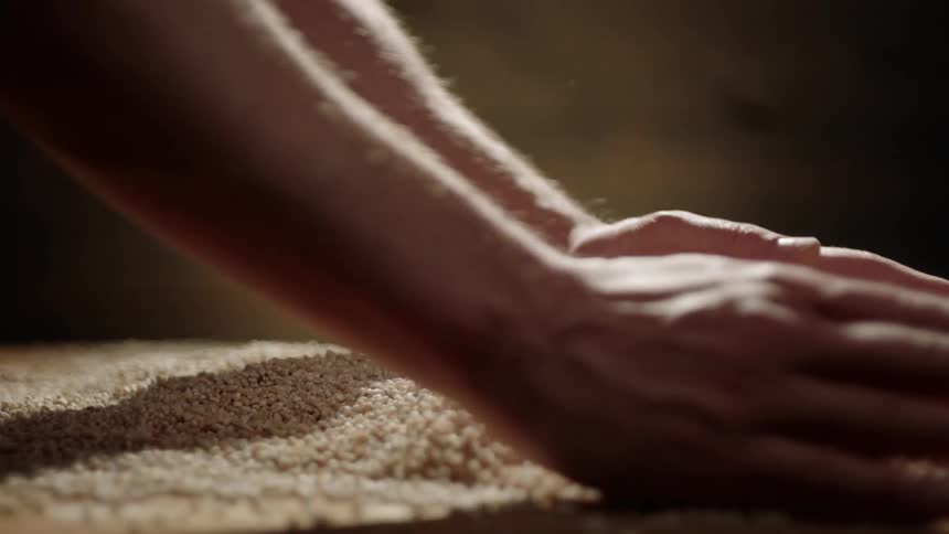 A man touches a pile of grain