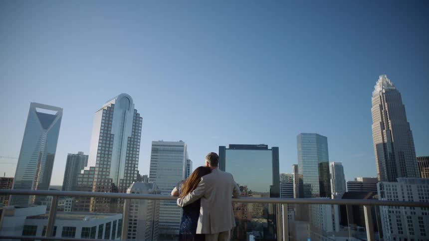 A man and woman embrace as the look out at the city