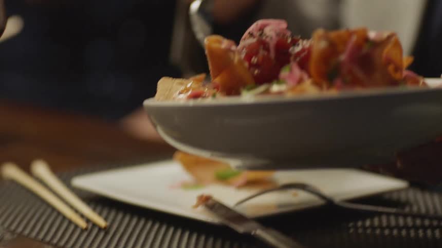 A person eats a nacho bowl