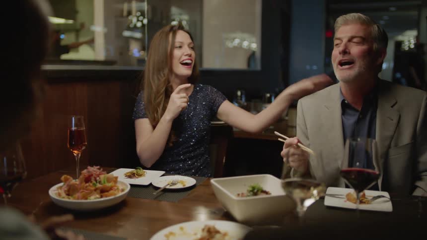 People sit at the table talking and eating