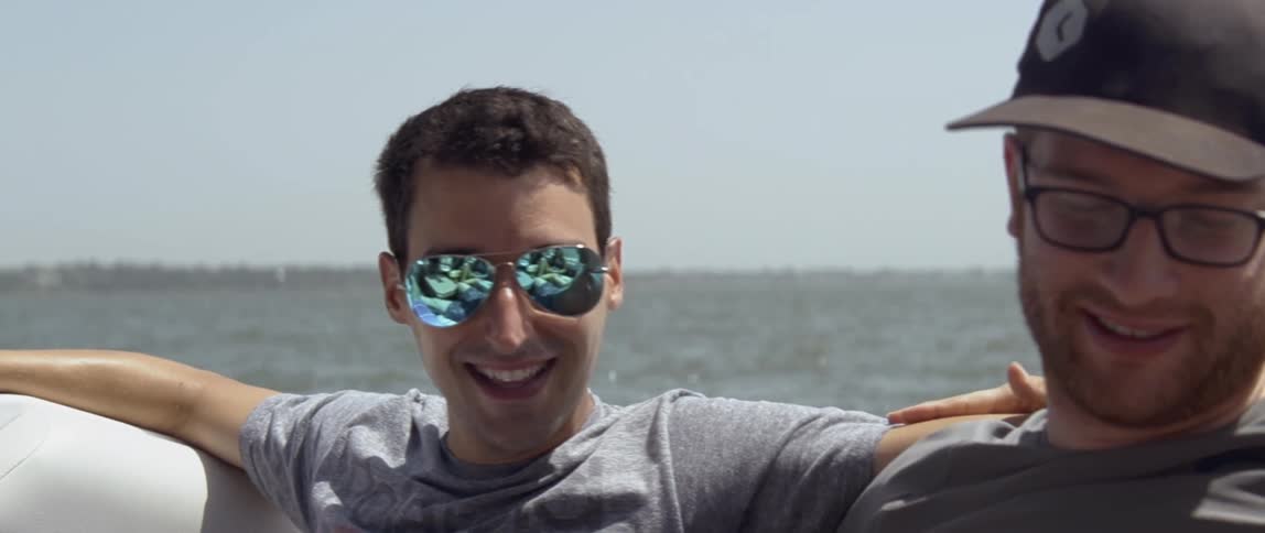 Smiling man sits on a raft on a sunny day