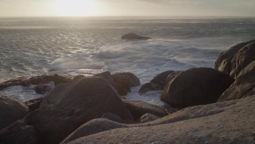 Ocean waves crash to shore on a sunny day