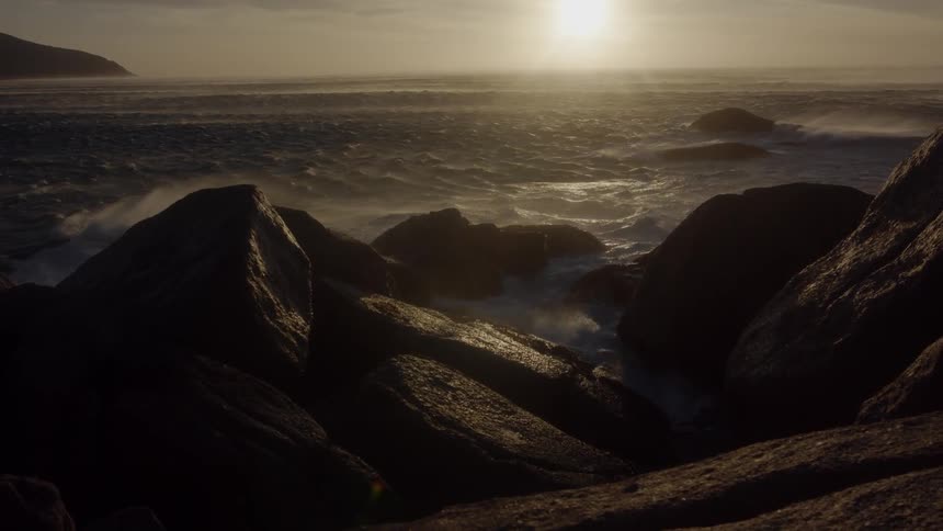 Ocean waves splash against the rocks near shore