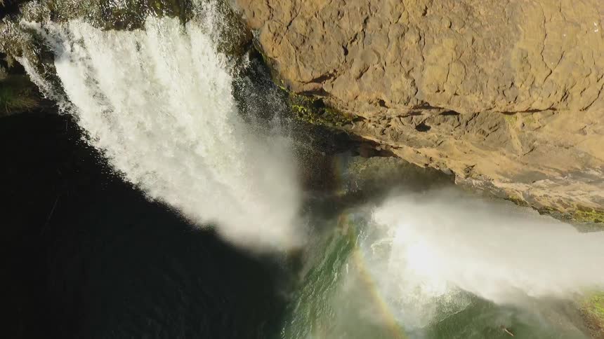 Water falls off the side of the cliff