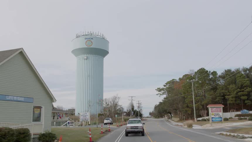 A truck travels on a road through a rural town
