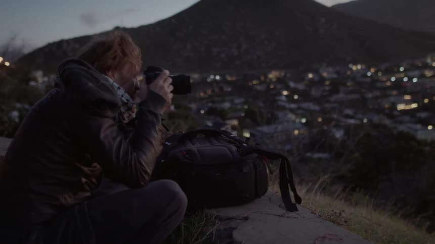 Smiling man takes pictures of nature at sunset