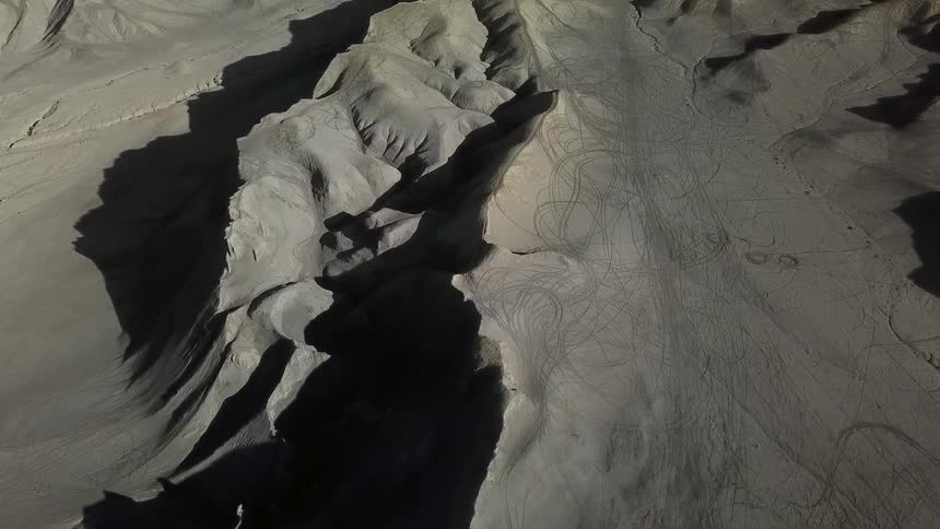 Tracks mark the sand and dirt of dunes and slopes