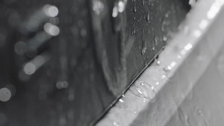 Water beads and falls off the side of a car