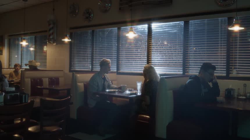 Man and woman talk as they sit at a table in a restaurant