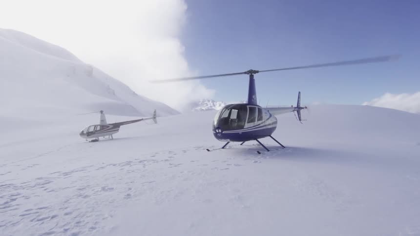 Helicopters running and parked on a snowy surface