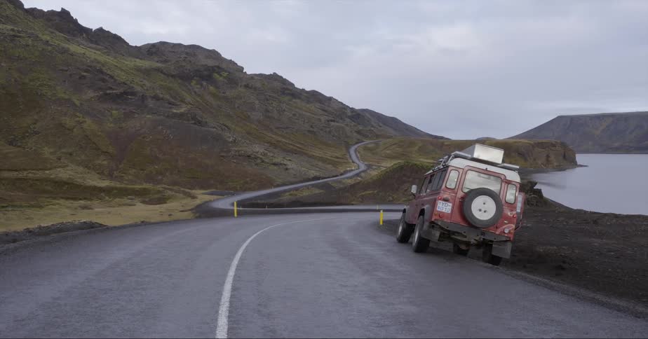A truck is parked on the side of a rural hill road