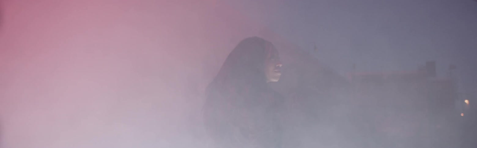Woman wearing a jacket walks through the smoke