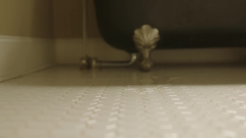 Foot of a bathtub on a bathroom floor