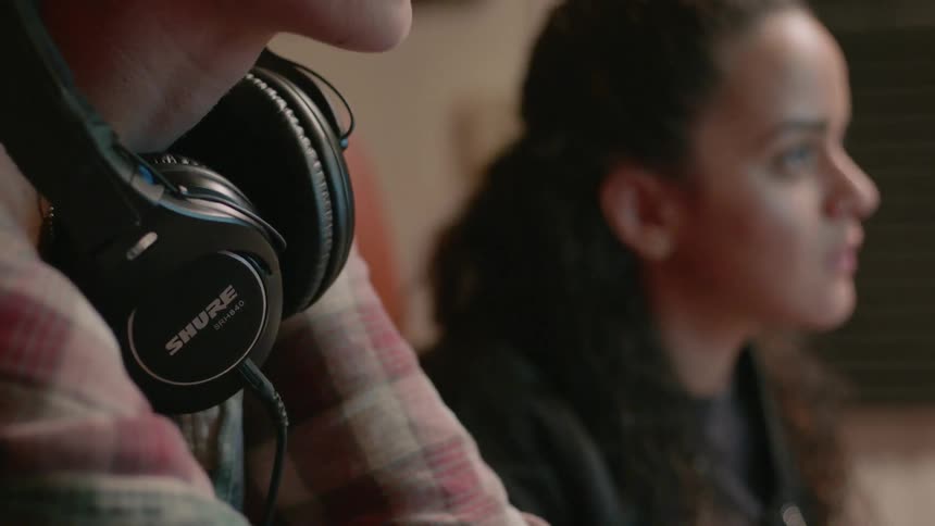 A man wears monitoring headphones around his neck