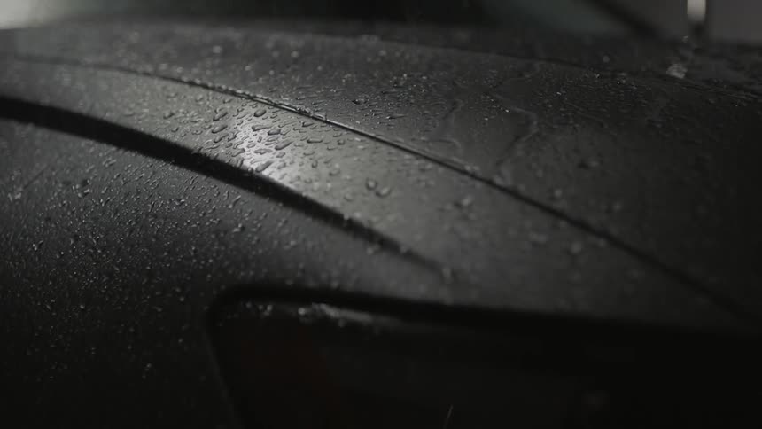 Water falls on to the hood of a car