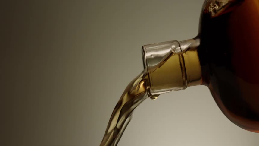 Bottle pours out amber colored liquid