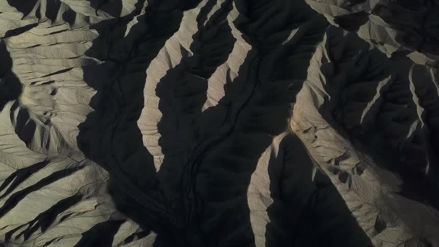 Shadows fall over hilly desert landscape
