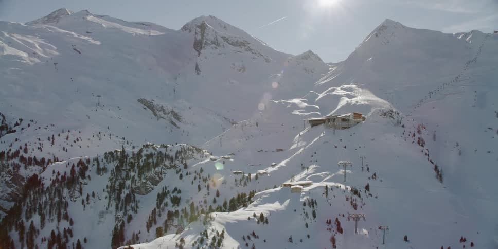 The sun shines on the snow covered mountains