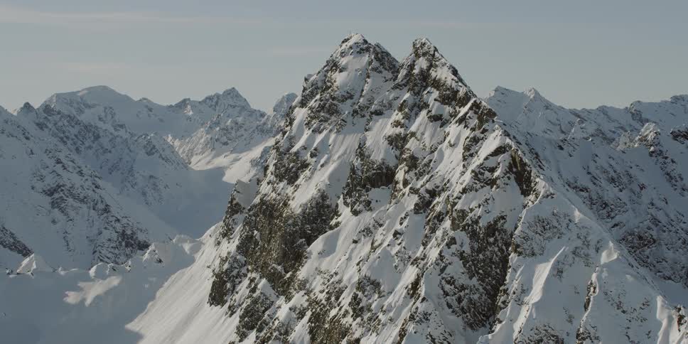 Tall rocky snowy mountains on a sunny day