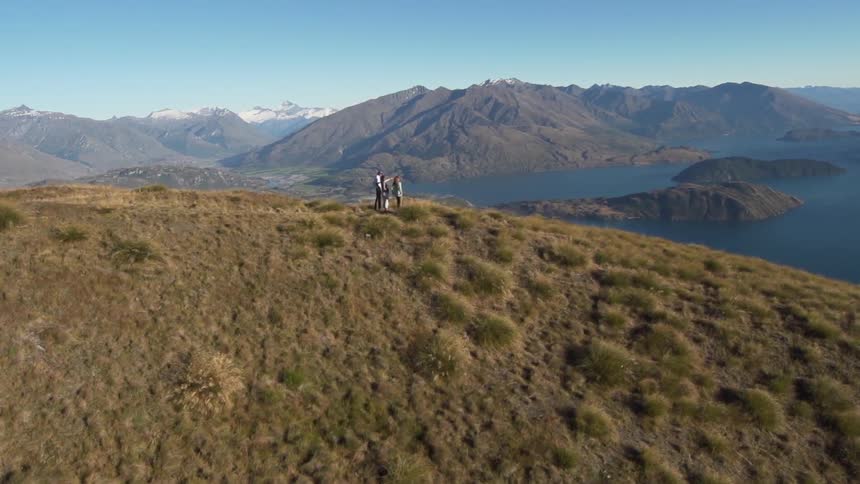 People standing on a hill by some water