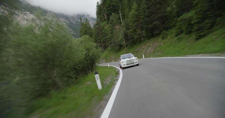 A touring car is driven by the lake