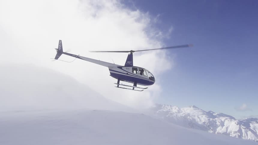 A helicopter flying over a snow covered mountain