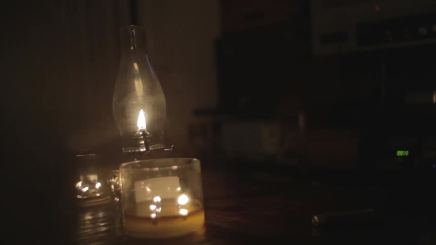 Candles and a lantern light a room