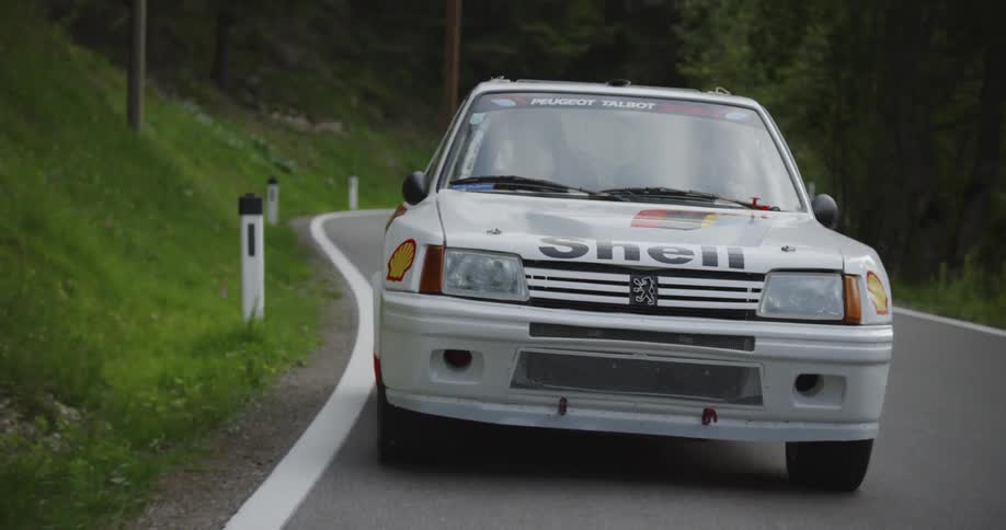 A touring car speeds down the mountain road