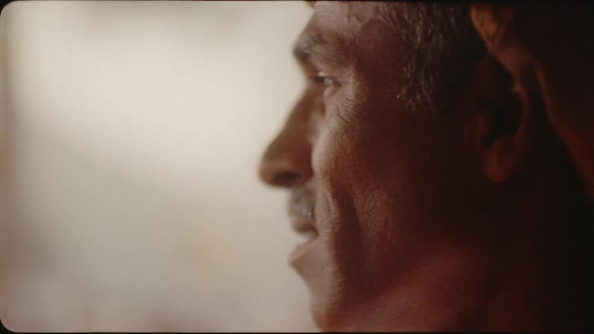 A man is smiling as he looks outside