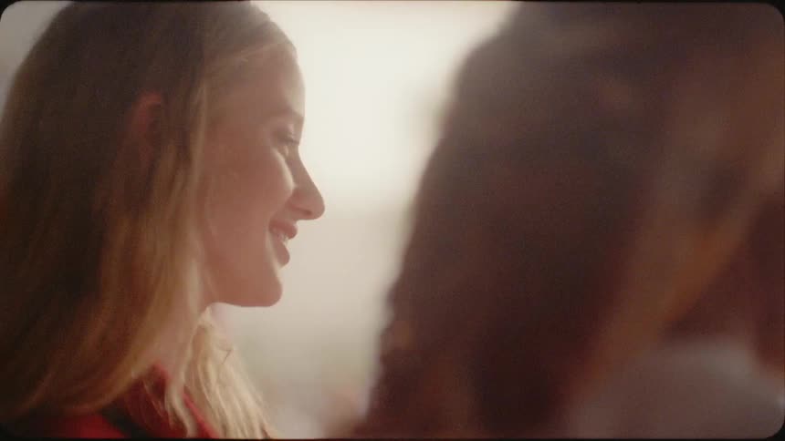 A woman smiles as she talks to a man