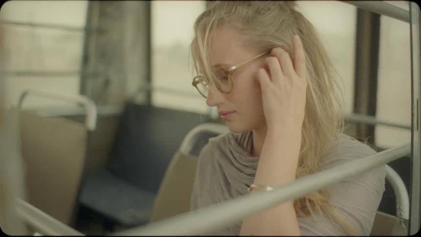 A blond haired woman sits in the back of a van
