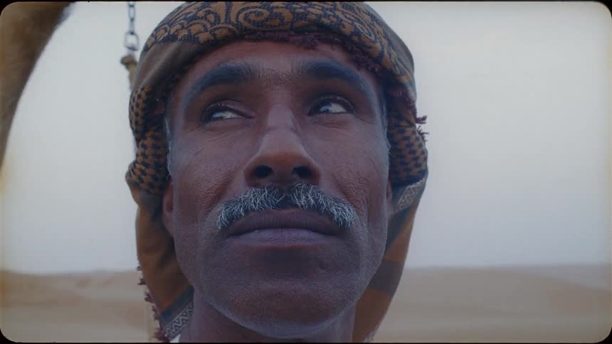 Man blinks and looks out across the desert