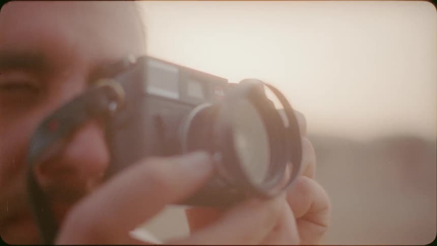 A man focuses and takes a photograph outside