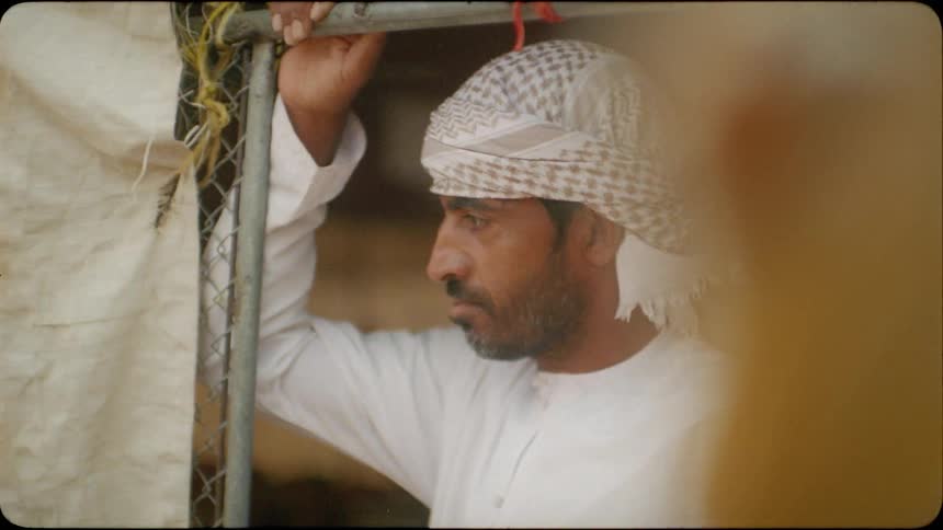 Man looks out of a doorway of a hut