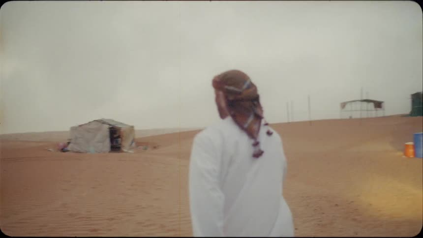 Man exits a vehicle and walks across the sand