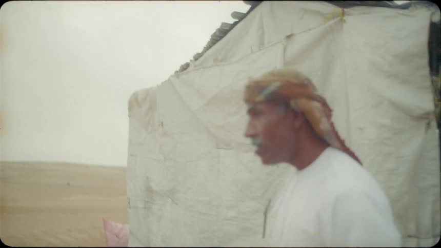 A group of men carry food from a tent in the desert