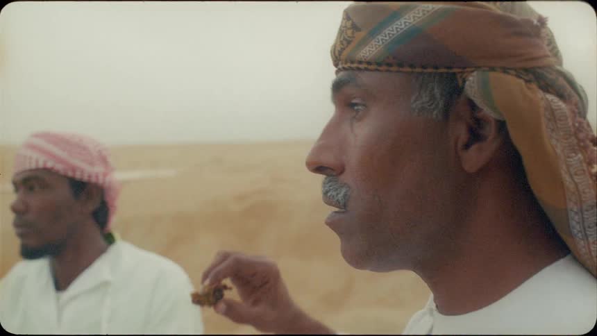 A group of middle eastern men dine together in the desert