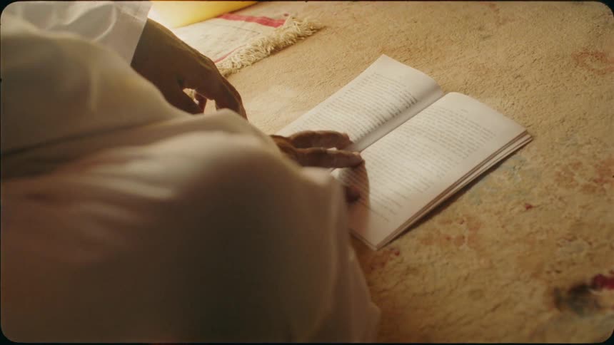 A man reads a book on the ground
