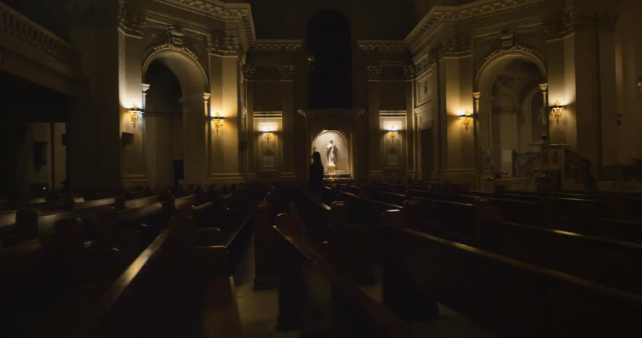 Church with lights along the wall and many pews